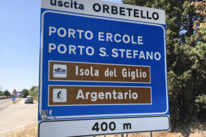 Cartello stradale con indicazioni per Porto S. Stefano e imbarchi per l'Isola del Giglio