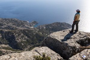 Persona che amira il panorama dell'Isola di Montecristo durante il trekking
