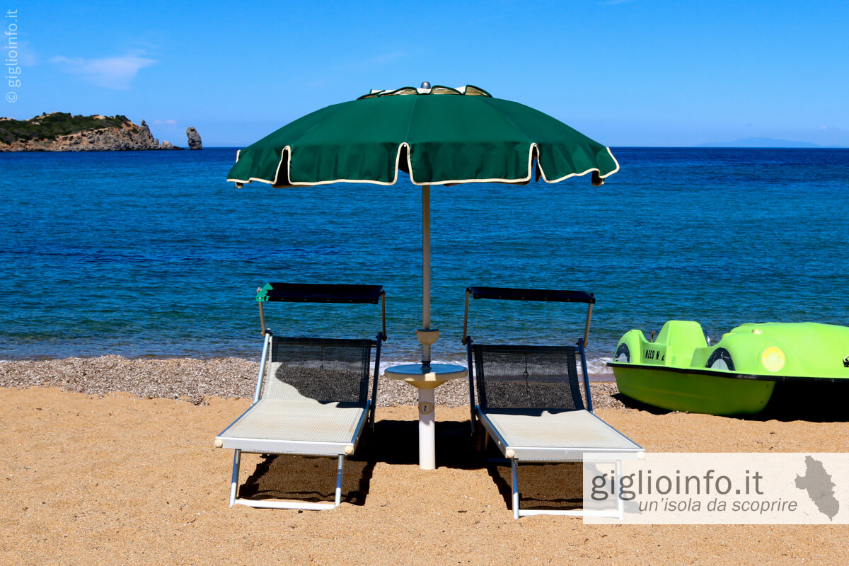 Lettini e ombrello con baia del Campese Bagno da Meco, Spiaggia del Campese, Isola del Giglio