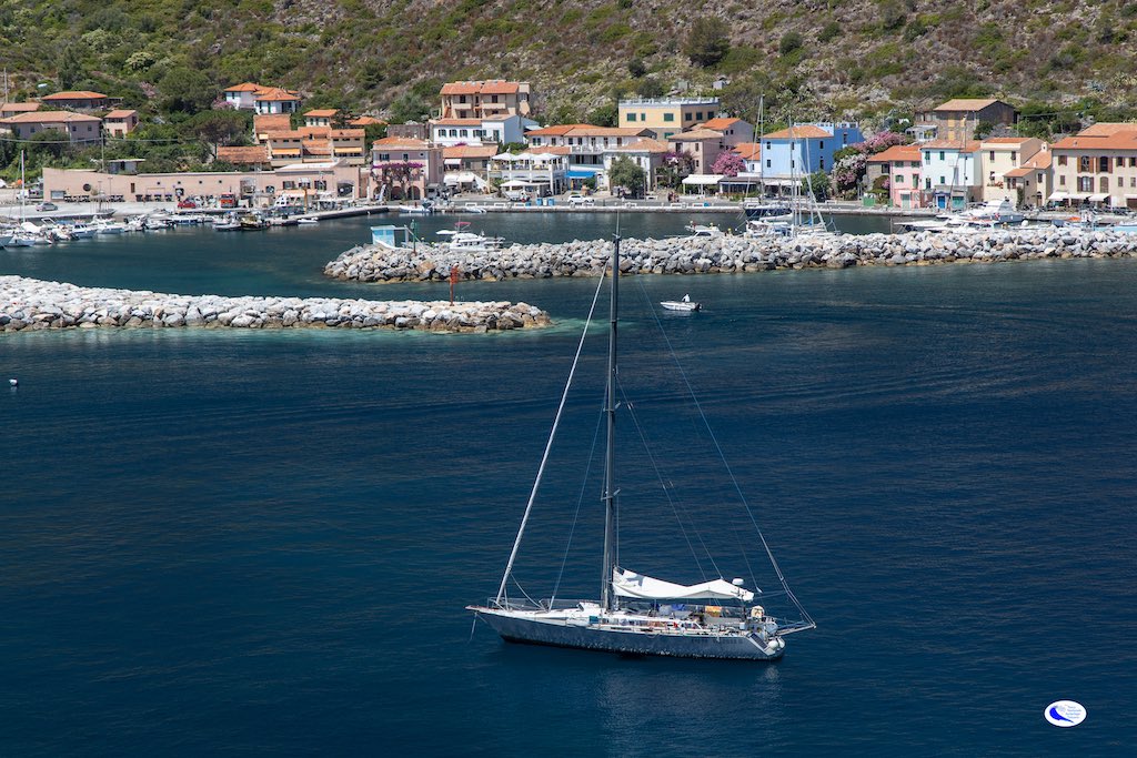 Veduta del porto di Capraia, isola di Capraia, Arcipelago toscna con barca a vela