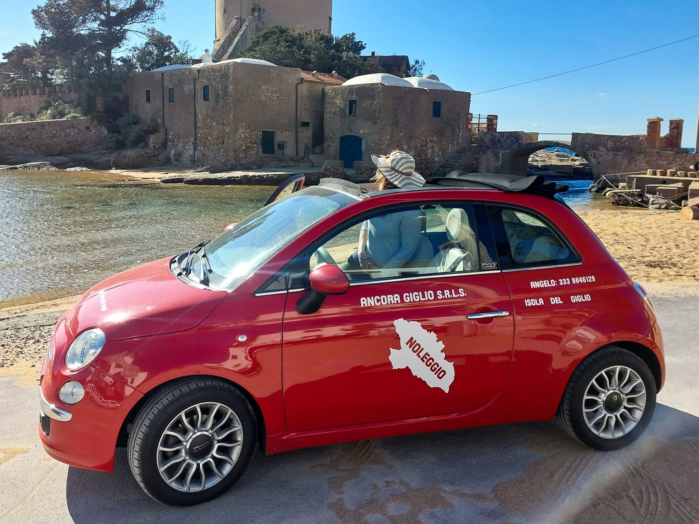 Fiat 500 rosso davanti alla torre di Giglio Campese autonoleggio Ancora