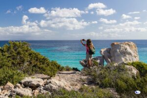 Donna che fa una foto del mare sull'Isola di Pianosa durante un'escursione di Trekking