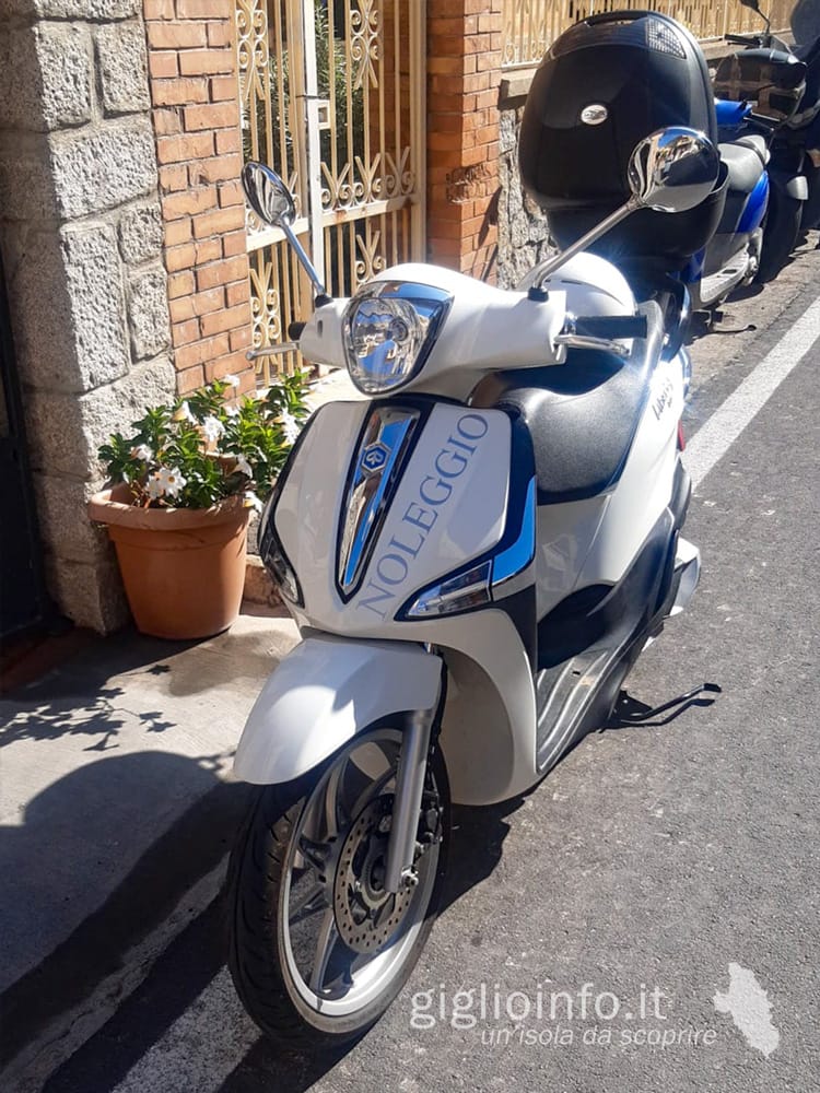 Scooter Piaggio Liberty 125cc bianco davanti all'negozio Giglionoleggio, Noleggio Scooter Isola del Giglio Porto