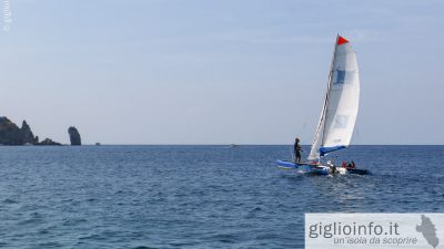 Trimarano nella baia di Campese con Fraglione, Isola del Giglio, Arcipelago Toscano